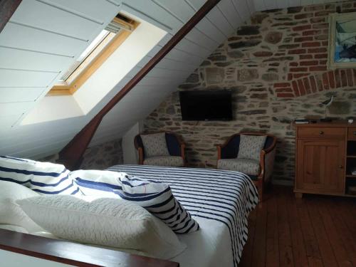 een slaapkamer met een bed en een stenen muur bij studio Marie in Cancale