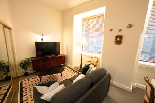 uma sala de estar com um sofá e uma televisão de ecrã plano em Vintage Charm in the Heart of Sydney CBD close to the Opera House em Sydney