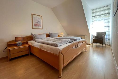 a bedroom with a bed and a chair in it at Ferienwohnung-4-mit-Sonnenbalkon-im-Landhaus-Hubertus-Duhnen in Cuxhaven