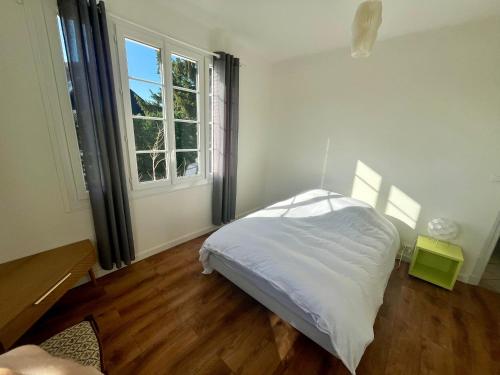 um quarto com uma cama branca e uma janela em MAISON FLEURS - 5min de Vichy - Jardin - Calme em Creuzier-le-Vieux