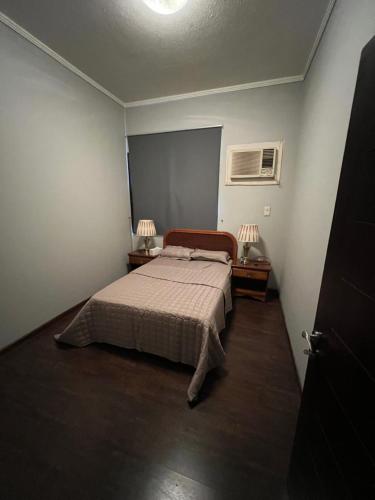 ein Schlafzimmer mit einem Bett und zwei Lampen an Tischen in der Unterkunft شقة غرفتين وصاله بتصميم مودرن in Riad