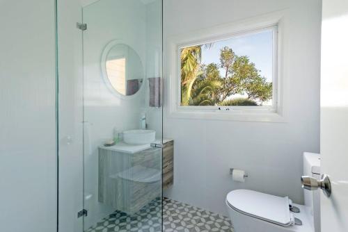 baño con aseo y lavabo y ventana en Ocean Views - Beach Retreat, en Copacabana