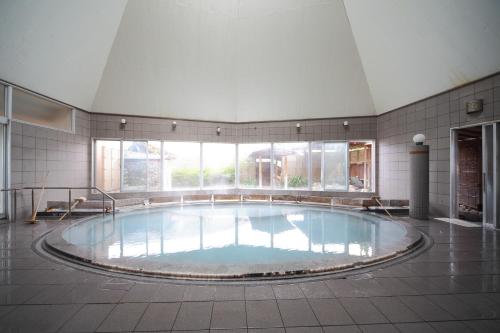白浜町にある白浜温泉 柳屋の大きな窓付きの客室内の大きなスイミングプールを提供しています。