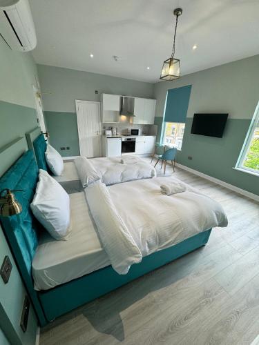 a bedroom with two beds and a blue couch at The Chapter Hotels - Finsbury Park in London