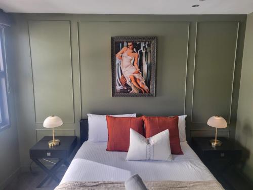 1 dormitorio con 1 cama con una pintura en la pared en Penthouse Living Premium Location by Custom Bnb Hosting, en Melbourne