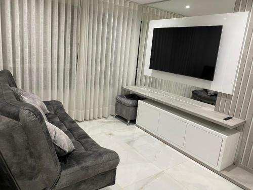 een woonkamer met een bank en een flatscreen-tv bij Hermoso apartamento en El Poblado in Medellín