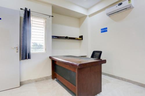 OYO Gaur Nitay في Dahmi: مكتب مع مكتب وهاتف في الغرفة