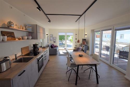 een keuken met een houten tafel en een eetkamer bij Meeresblick "Enna Mare" Haus 1 - Ferienwohnung 5 in Hohwacht
