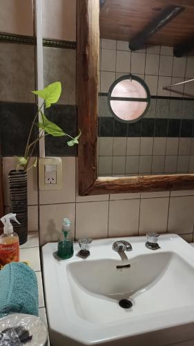lavabo blanco en el baño con espejo en El Parralito en Mendoza