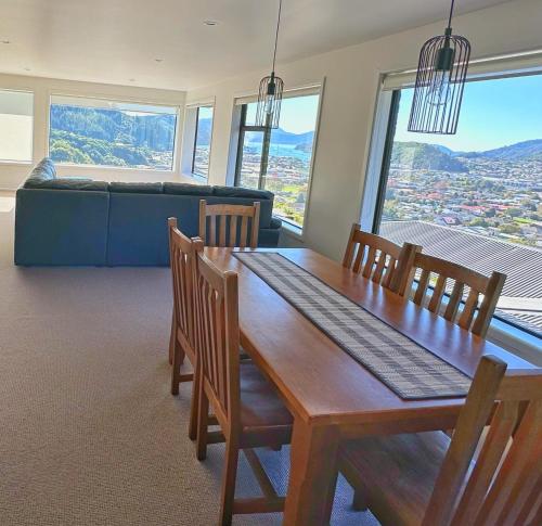 a dining room with a table and chairs and a couch at Picton Hilltop Apartment in Picton