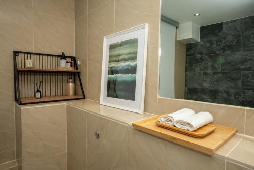 uma casa de banho com toalhas numa prateleira de madeira e um espelho em Prime Central London Apartment - Covent Garden em Londres