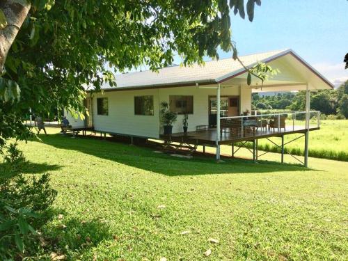 a small white house with a porch and a yard at Mission Beach Rural Escape in Mission Beach