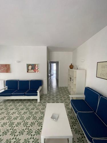 a living room with blue couches and a table at channel house in Ischia Town