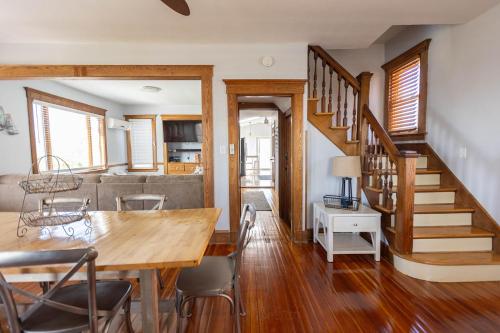 uma sala de jantar e sala de estar com uma mesa de madeira e escadas em Beachside Retreat em West Haven