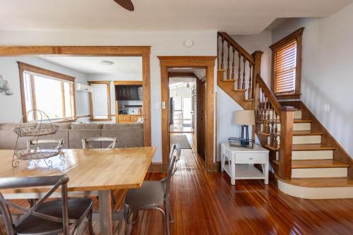 a dining room and living room with a wooden table and stairs at Beachside Retreat in West Haven