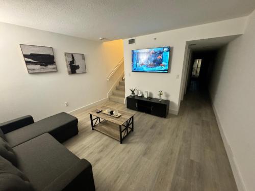 a living room with a couch and a tv on a wall at Apartamento en kendall Miami 2 Habitaciones y 3 baños in Miami