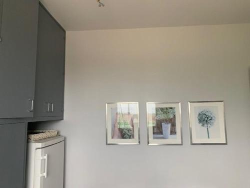 une cuisine avec trois photos sur le mur dans l'établissement Maison lumineuse avec jardin privatif, proche châteaux de la Loire, tennis gratuit et charme historique - FR-1-581-69, à Châteaudun