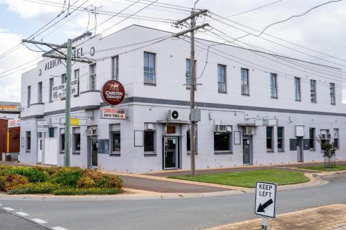 a white building on the corner of a street at Converted Historic Hotel in Finley, Sleeps 25 in Finley