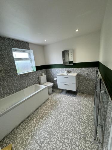 uma casa de banho com uma banheira, um WC e um lavatório. em The Chapter Hotels - Finsbury Park em Londres