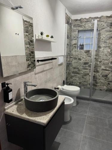 a bathroom with a sink and a toilet and a shower at Casa Stewart - Ponente in Geremèas