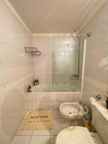 a bathroom with a tub and a toilet and a sink at Edificio Millenium Apartment in Mendoza