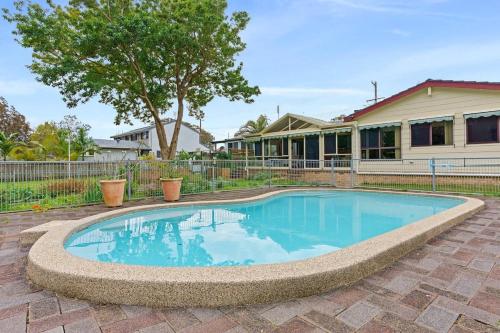 a swimming pool in front of a house at Waterfront Pet-Friendly Abode - Toukley NSW in Toukley