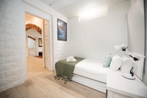 a white bedroom with a bed and a lamp at Absolute Waterfront Hidden Gem, Toukley in Toukley