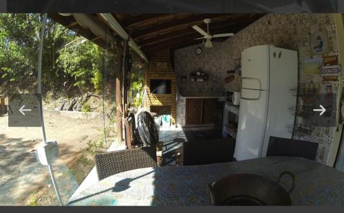 cocina con nevera y mesa con sillas en Chalé no Camping Carrion próximo a Tomorrowland en Itu