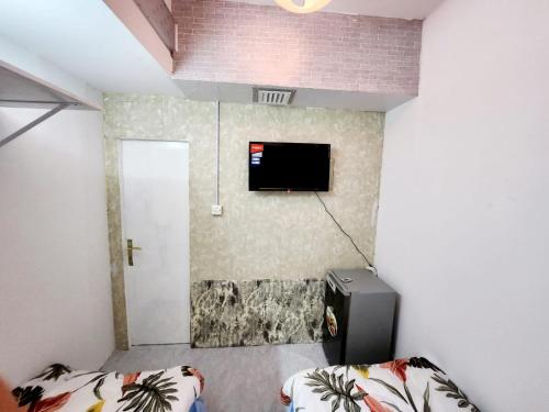 Habitación con 2 camas y TV en la pared. en Room For 2 Person Close to Metro en Dubái