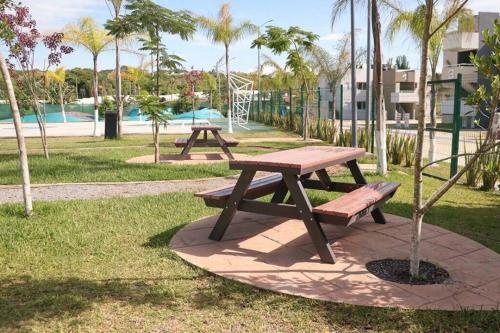 two picnic tables in a park with palm trees at Depa Ye in El Alcanfor