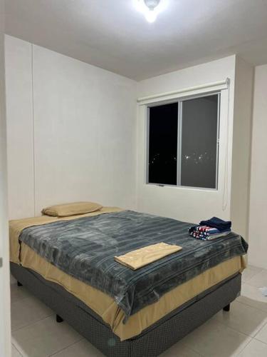 a bed in a white room with a window at Depa Ye in El Alcanfor