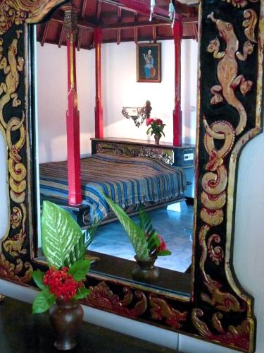 a mirror with a bed in a room at Puri Bunga Beach Cottages in Senggigi 