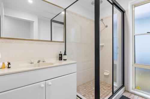 La salle de bains est pourvue d'une douche et d'un lavabo. dans l'établissement Amazing Water -Front Family Escape - Blue Bay, à Blue Bay 