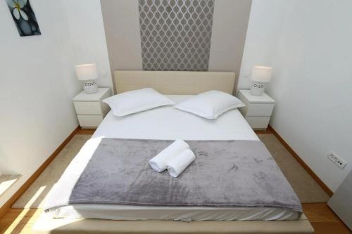 - une chambre avec un grand lit blanc et 2 tables de chevet dans l'établissement Apartments with a swimming pool Stobrec, Split - 22897, à Podstrana
