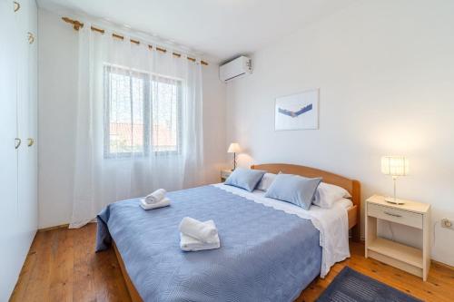 a bedroom with a large bed with two towels on it at Holiday house with a parking space Sutivan, Brac - 23075 in Supetar