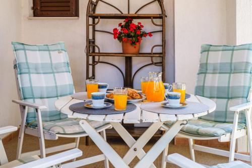 a breakfast table with orange juice and croissants at Holiday house with a parking space Sutivan, Brac - 23075 in Supetar