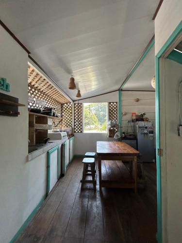 a kitchen with a wooden table and a wooden floor at Backpacker Puerto Viejo in Puerto Viejo