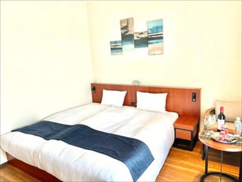 a bedroom with a large bed with a table at THE GRAND HOTEL GINOWAN in Ginowan
