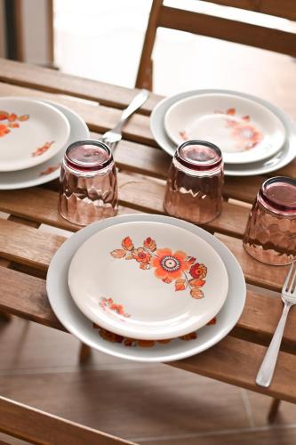 a table with plates and glasses on a wooden table at Il Vicoletto sul Mare in Ischia