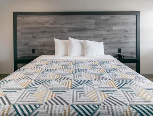 a bed with a colorful quilt on top of it at Motel 6 Pico Rivera - Los Angeles, CA in Pico Rivera