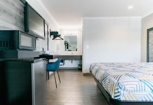 a bedroom with a bed and a desk and a kitchen at Motel 6 Pico Rivera - Los Angeles, CA in Pico Rivera