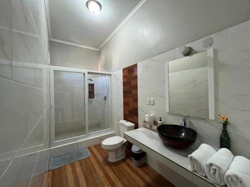 a bathroom with a sink and a shower and a toilet at Mango Hostel in Comayagua