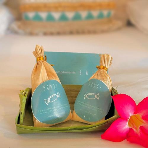 a couple of wedding rings in bags on a tray with flowers at Salt Resort & Spa in Amed