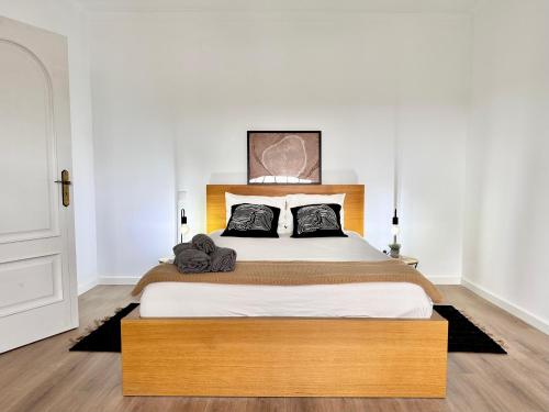 a bedroom with a large bed with a wooden headboard at Casa da Mãe Ju in Porto de Mós