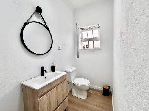 y baño con aseo blanco y espejo. en Casa da Mãe Ju, en Porto de Mós
