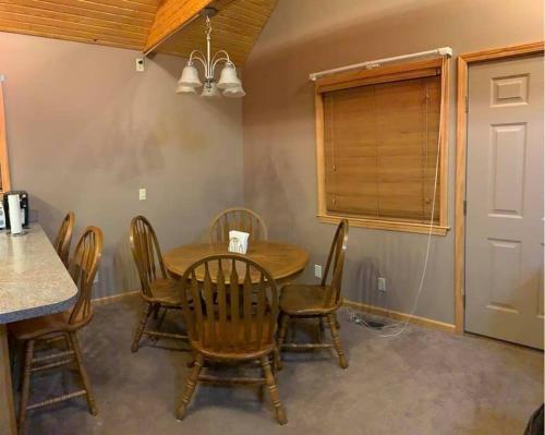 una sala da pranzo con tavolo e sedie in legno di Summersville Lake Rd Cabin - Pet Friendly! a Mount Nebo