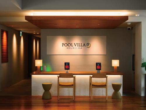 a hotel lobby with two chairs and a bar with a sign at Private condo Kourijima by Coldio Smart Resort in Nakijin