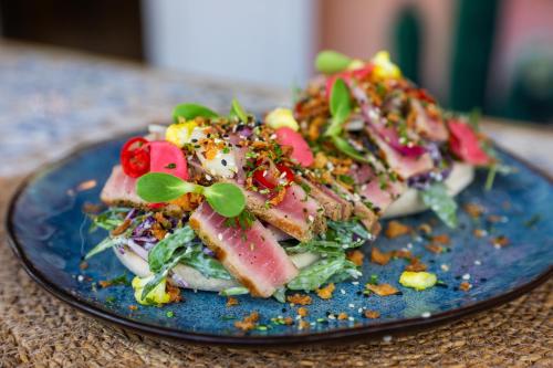 a blue plate with a salad on a table at Curaçao Gardens in Willemstad