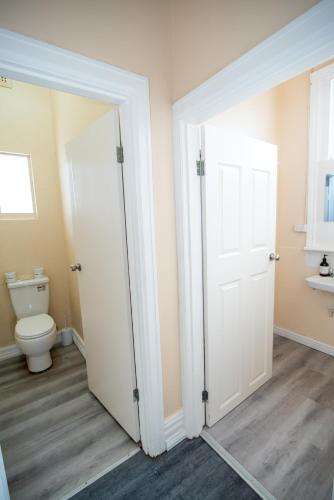 a bathroom with a toilet and a white door at Converted Historic Hotel in Finley, Sleeps 25 in Finley