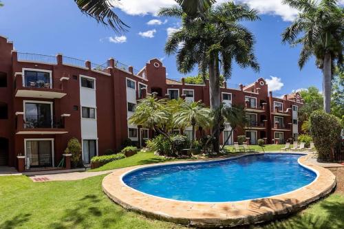 an apartment complex with a swimming pool in front of a building at Renovated condo in Tamarindo, 3 min from the beach in Tamarindo